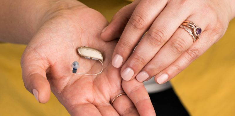 Hearing aid placed on the palm of a hand