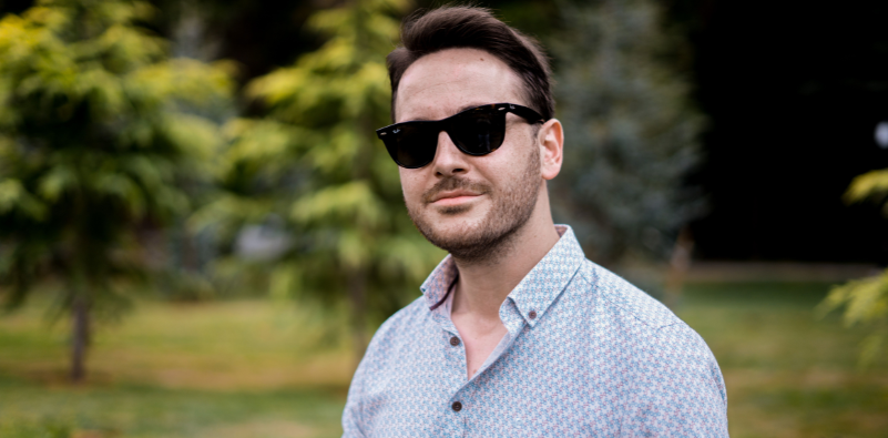 A man wearing Ray-Ban Wayfarer sunglasses outdoors