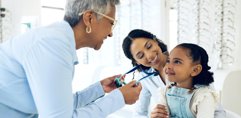 Child with a parent during an appointment with an optician choosing a pair of kids glasses.